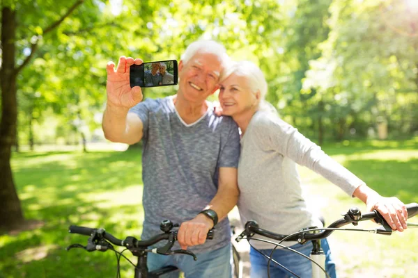 Ανώτερος ζευγάρι με ποδήλατα λήψη selfie Φωτογραφία Αρχείου