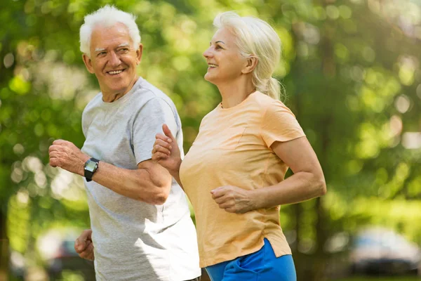 Senior couple running in park