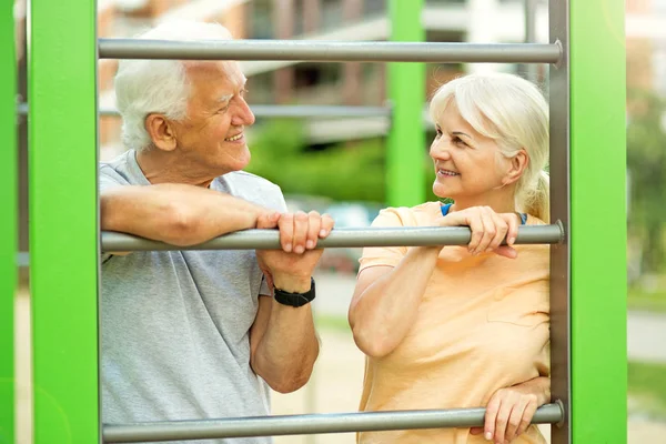 Äldre par tränar på utomhus gym Stockbild