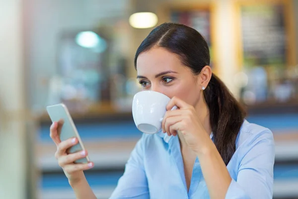 Žena s kávou a chytrý telefon — Stock fotografie