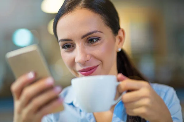 Kvinna med kaffe och smart telefon — Stockfoto