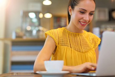 Kafede dizüstü bilgisayar kullanan kadın