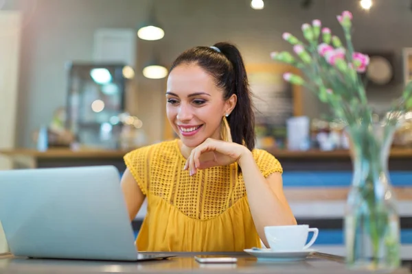 Kvinna som använder laptop i café — Stockfoto