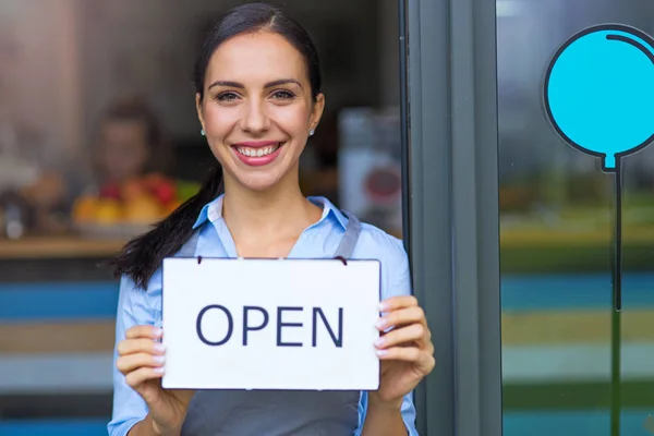 Frau mit offenem Schild in Café — Stockfoto