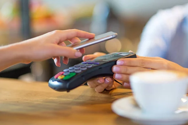 Клієнт платить через мобільний телефон в кафе Ліцензійні Стокові Фото