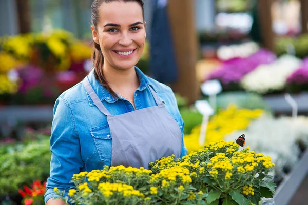 Funcionário sorridente no centro de jardim — Fotografia de Stock