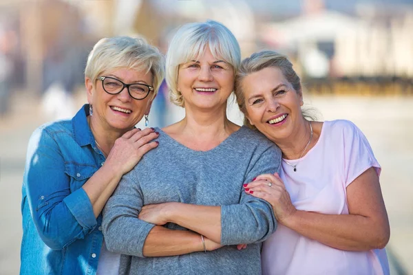 Grupp av leende äldre kvinnor som står utanför — Stockfoto