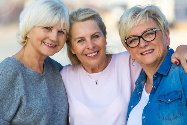 Gruppe av smilende eldre kvinner står utenfor – stockfoto