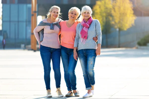 Grupp av leende äldre kvinnor som står utanför — Stockfoto