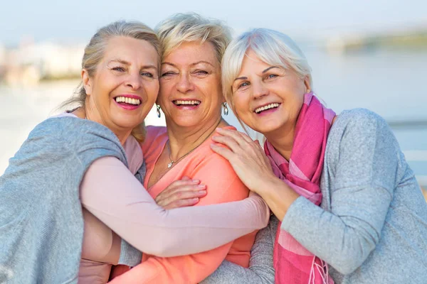 Gruppe av smilende eldre kvinner står utenfor – stockfoto