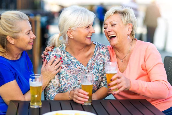 Üst düzey kadın açık bir barda bir bira gülümseyen — Stok fotoğraf