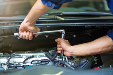 Oto tamircisi motoru üzerinde çalışan makinist