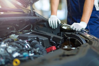 Oto tamircisi motoru üzerinde çalışan makinist