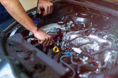 Oto tamircisi motoru üzerinde çalışan makinist