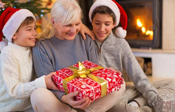 Avó Com Seus Dois Netos Segurando Presente Natal — Fotografia de Stock
