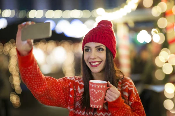 女性のクリスマス市場でスマート フォンを使用して — ストック写真