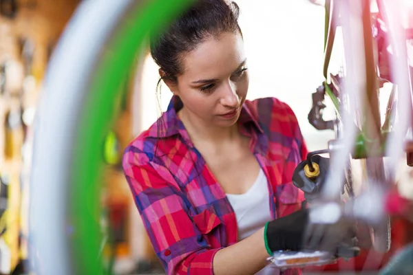 Νεαρή Γυναίκα Που Εργάζεται Ένα Κατάστημα Επισκευής Ποδηλάτων — Φωτογραφία Αρχείου