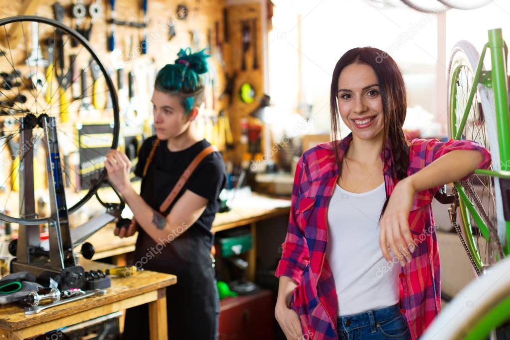 Two young women working in a bicycle repair shop