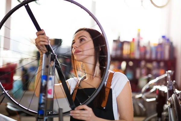 Νεαρή Γυναίκα Που Εργάζεται Ένα Κατάστημα Επισκευής Ποδηλάτων — Φωτογραφία Αρχείου