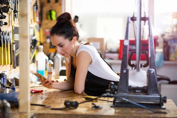 Giovane Donna Che Lavora Negozio Riparazione Biciclette — Foto Stock