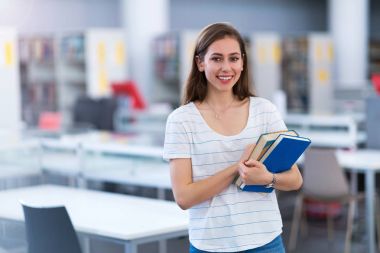 Kütüphanede okuyan genç kız öğrenci