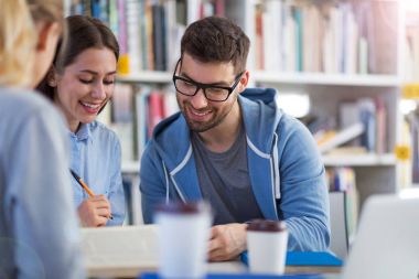Üniversite öğrencileri kampüs kütüphanede çalışma