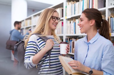 Üniversite öğrencileri kampüs kütüphanede çalışma