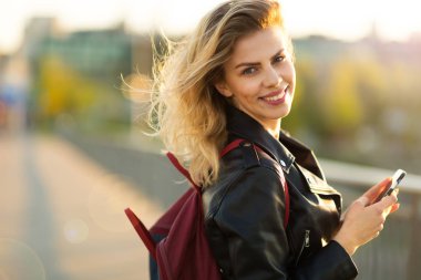 Dışarıda cep telefonu kullanan genç bir kadın.