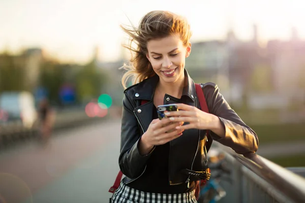 屋外で携帯電話を使う若い女性は — ストック写真