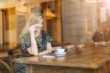 Café'de akıllı telefon kullanan güzel genç kadın