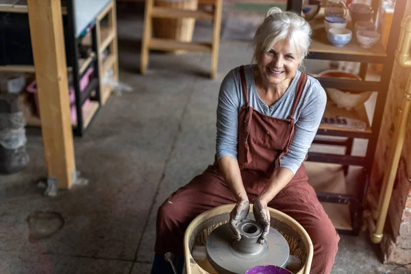 Starsza Kobieta Wykonująca Ceramiczną Pracę Kołem Garncarskim Zdjęcie Stockowe