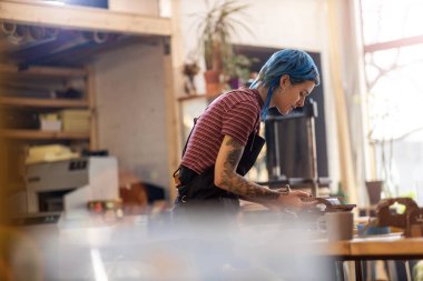 Atölyesinde kendine güvenen genç bir zanaatkar.