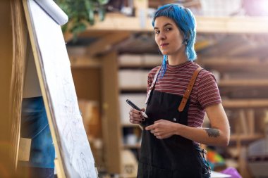 Kadın tasarımcı atölyede yeni projesini çiziyor