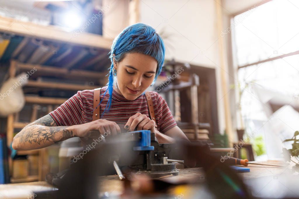 Confident young craftswoman in her workshop