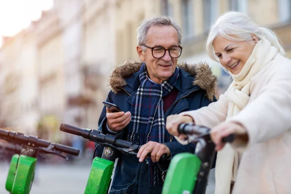 Casal Sênior Com Scooter Elétrico Smartphone Cidade — Fotografia de Stock