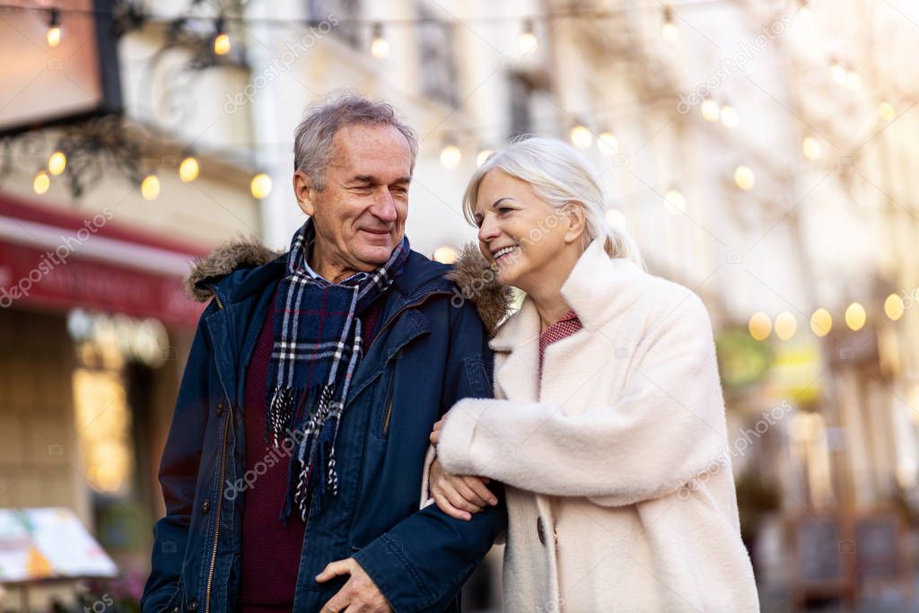 Senior couple walking on the city street at winter day