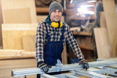 Kereste deposunda genç bir erkek işçi 