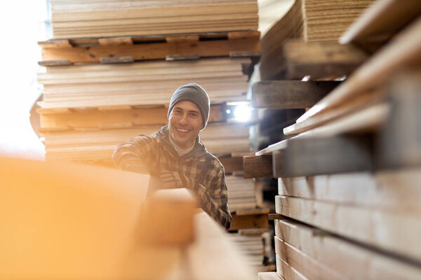 Young male worker in timber warehouse 
