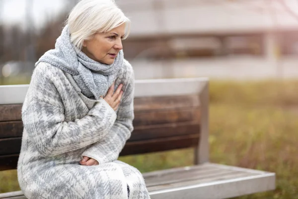 Senior Vrouw Lijden Aan Pijn Borst Tijdens Het Zitten Bank — Stockfoto