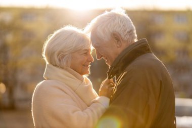 Senior couple hugging outdoors in autumn