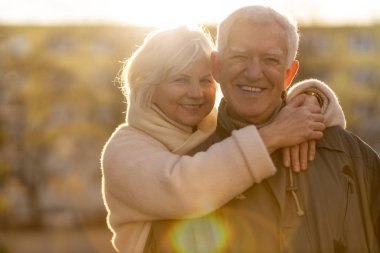 Senior couple hugging outdoors in autumn