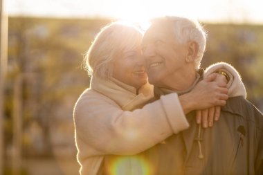 Senior couple hugging outdoors in autumn