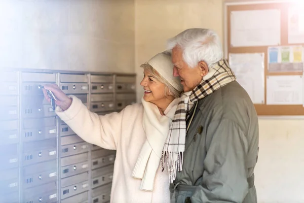 Senior couple unlocking apartment mailbox