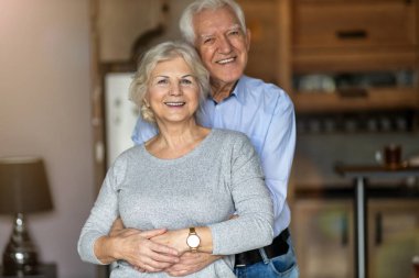 Happy senior couple embracing in their home 