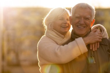 Senior couple hugging outdoors in autumn