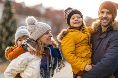 Sevecen genç aile bir şehirde kış gününün tadını çıkarıyor.