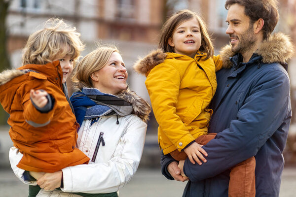 Affectionate young family enjoying winter day in a city