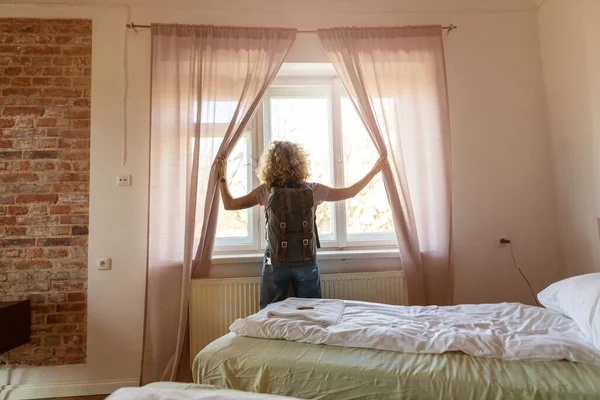 Achteraanzicht Van Toerist Hotelkamer Die Aan Gordijnen Trekt Het Uitzicht — Stockfoto