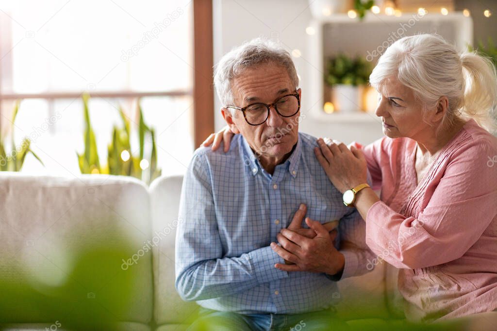 Senior woman helping her husband with chest pain