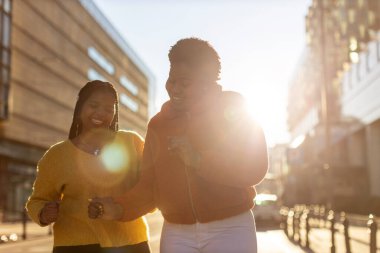 İki güzel Afro-Amerikan kadını şehirde birlikte eğleniyor.